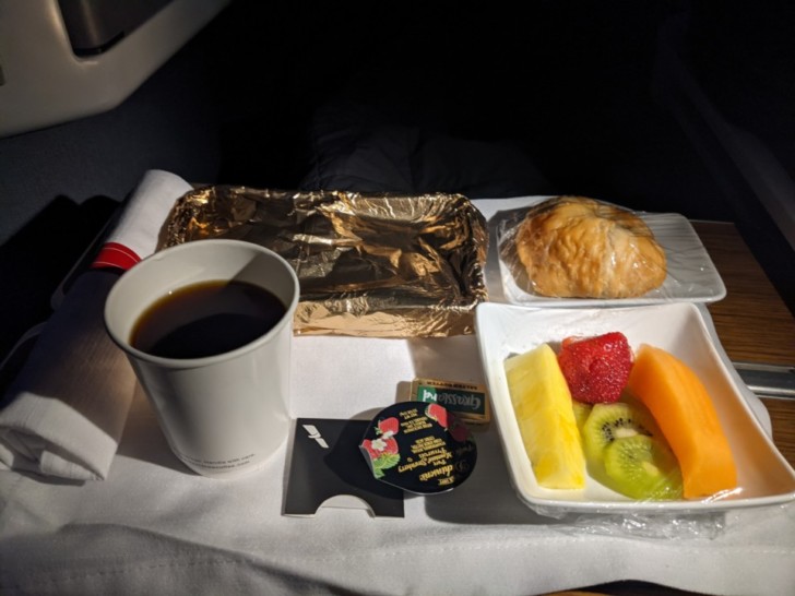 a tray of food and a cup of coffee on a table