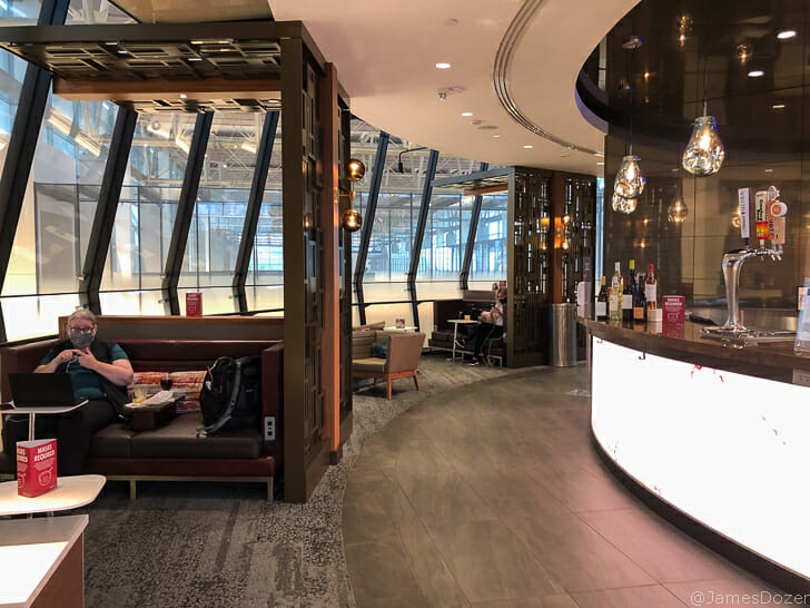 a man sitting on a couch in a room with a bar and a glass wall