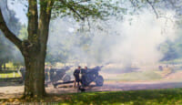 a group of men standing next to a cannon