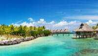 a body of water with a hut and a bridge