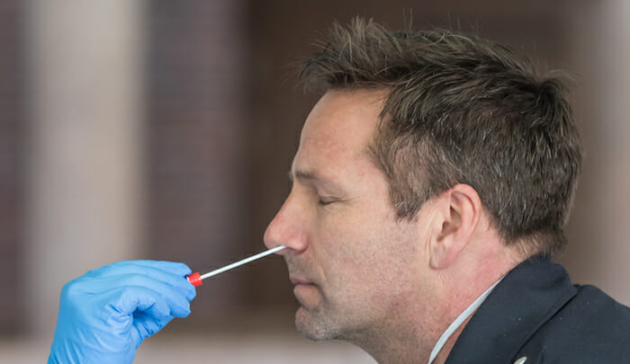 a man with a swab in his nose