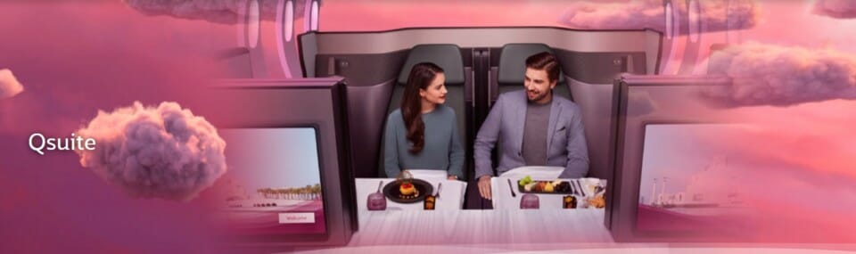 a man and woman sitting at a table in a plane