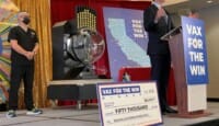 a man standing on a stage with a podium and a man standing on a stage