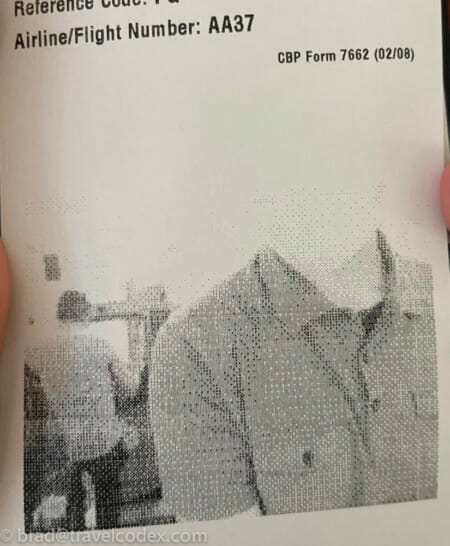 a hand holding a paper with a picture of a man