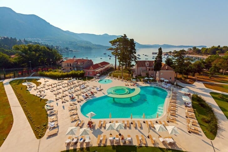 a pool with chairs and a large body of water