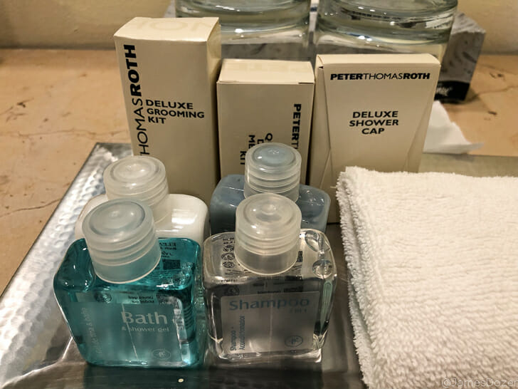 a group of small bottles of shampoo and a towel