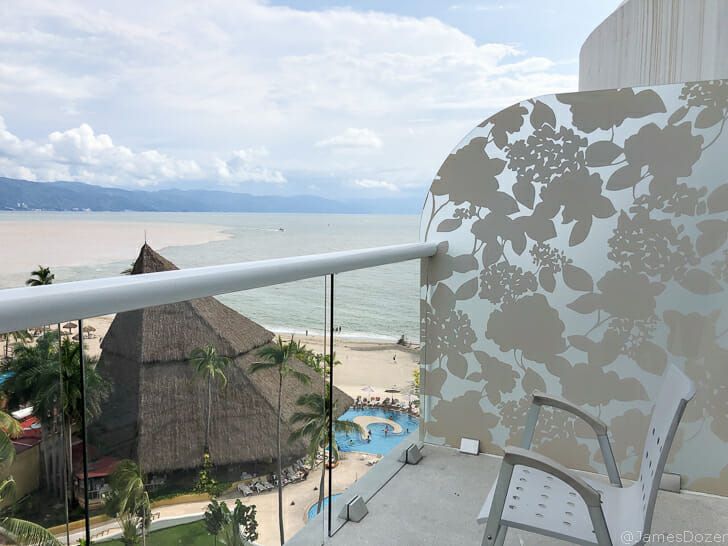 a balcony with a chair and a beach view