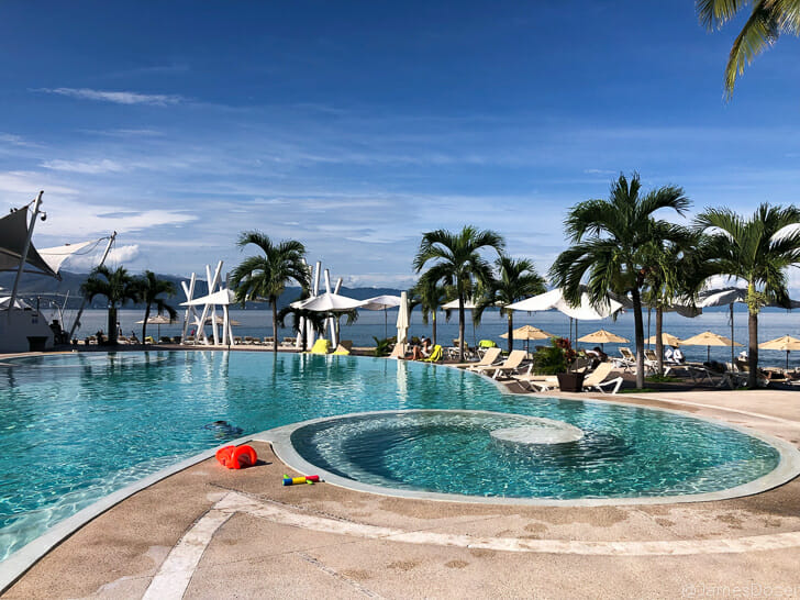 a pool with a beach and palm trees
