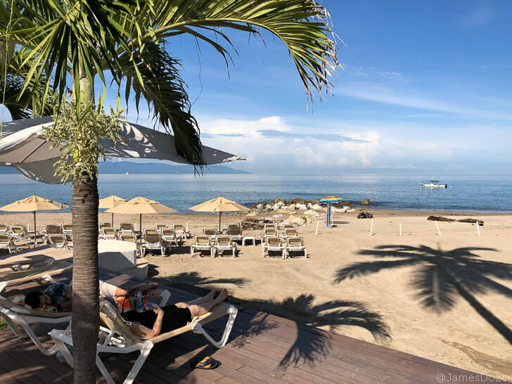 a man lying in a lounge chair on a beach