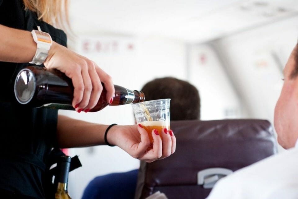 a person pouring a drink into a cup