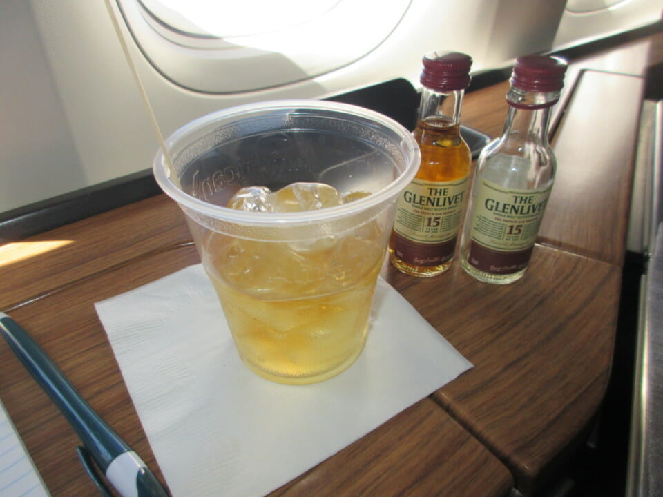 a cup of liquid and bottles of liquor on a table