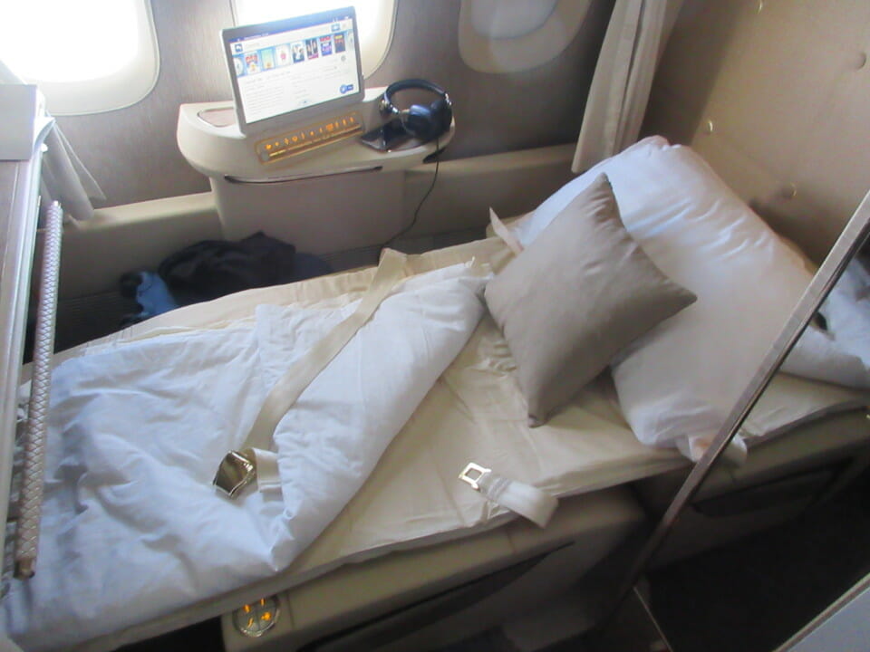 a bed with a seat belt and pillow on it