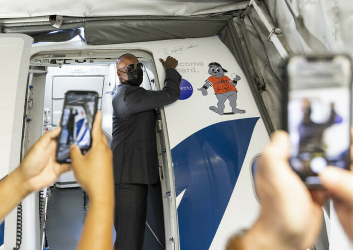 a man in a suit and mask standing in a plane