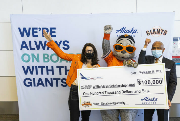 a group of people holding a check and a large sign