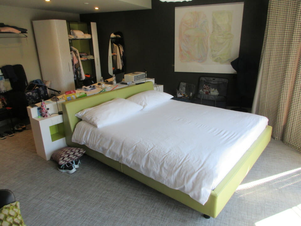 a bedroom with a bed and a painting on the wall