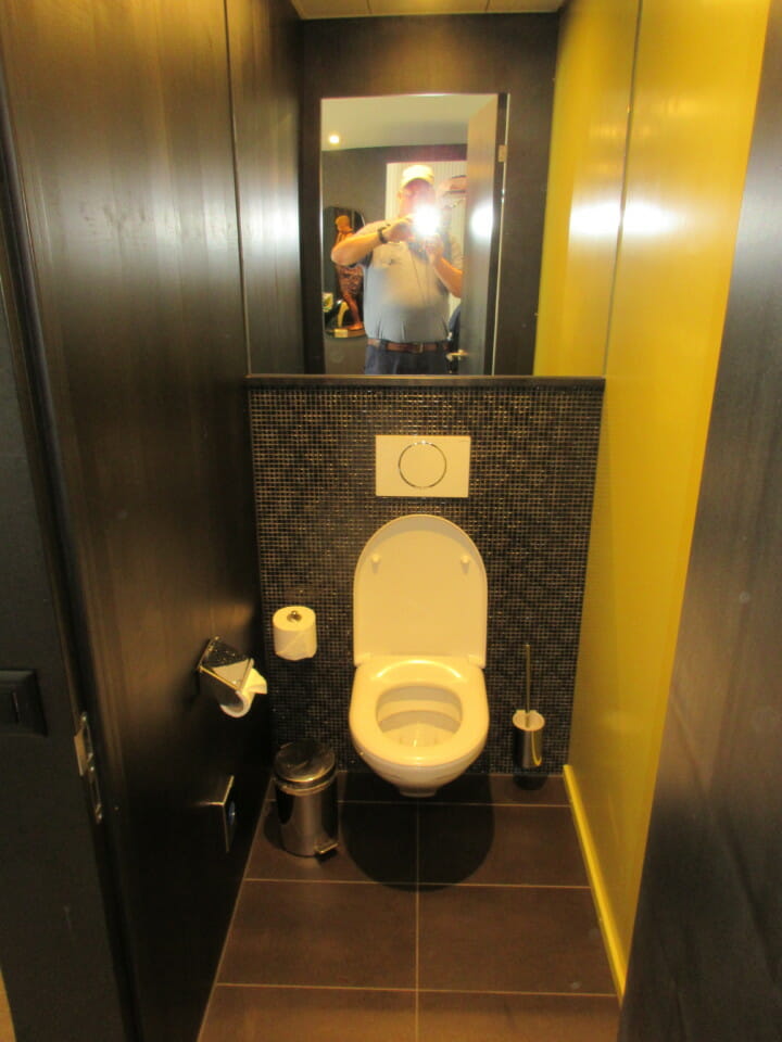 a man taking a picture of a toilet