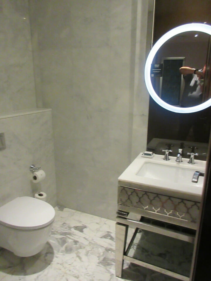 a bathroom with a round mirror and sink