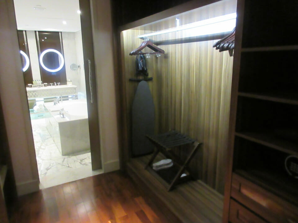 a room with a ironing board and a bathtub