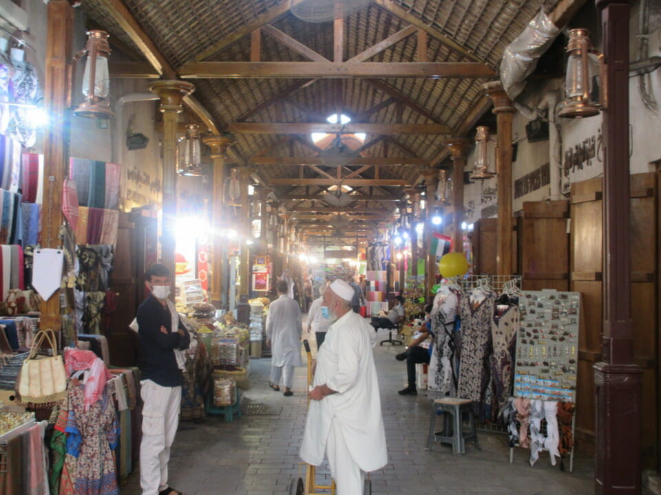 a man in a white robe and a cart in a market