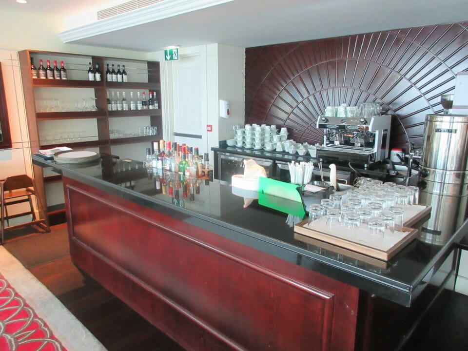 a bar with a black counter and wine glasses