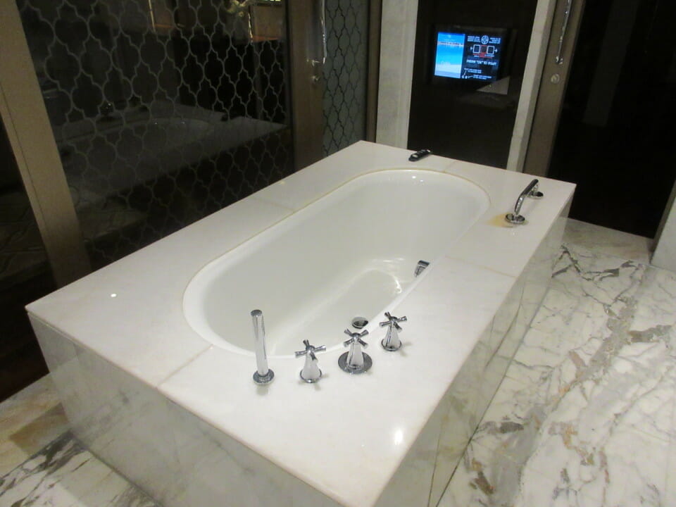 a white bathtub with silver faucets