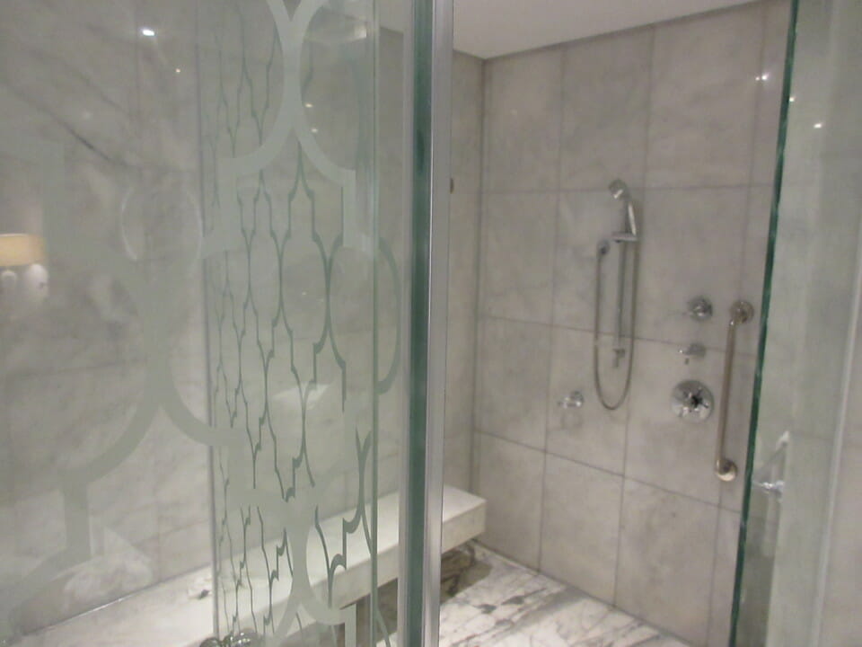 a shower with a bench and a glass door