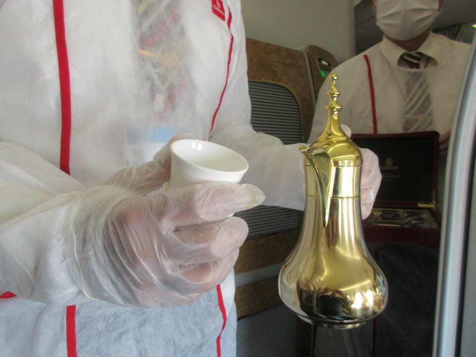 a person in white gloves holding a gold object