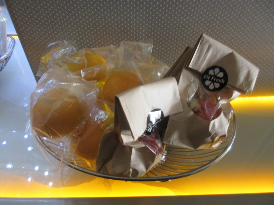 a bowl of fruit and bags of food