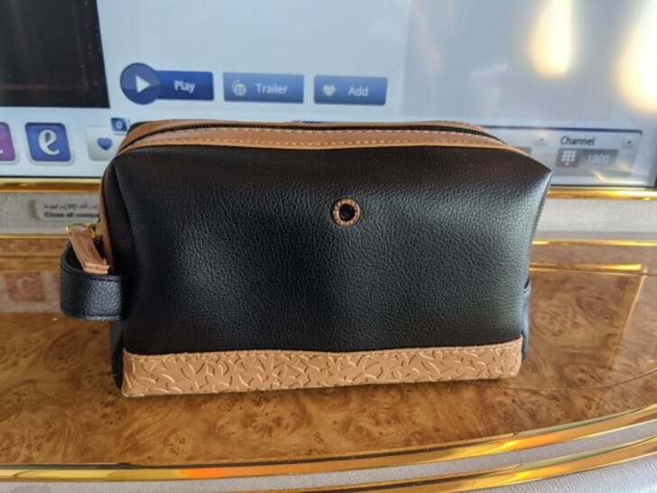 a black and tan purse on a gold tray