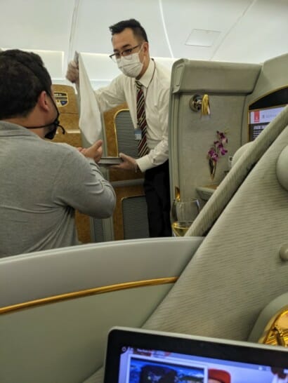 a man in a mask and tie standing in a chair with a man in a suit