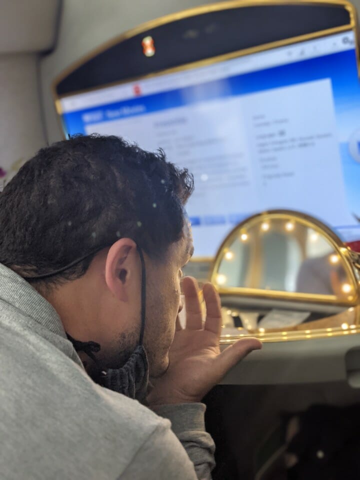 a man in a mask looking at a computer screen