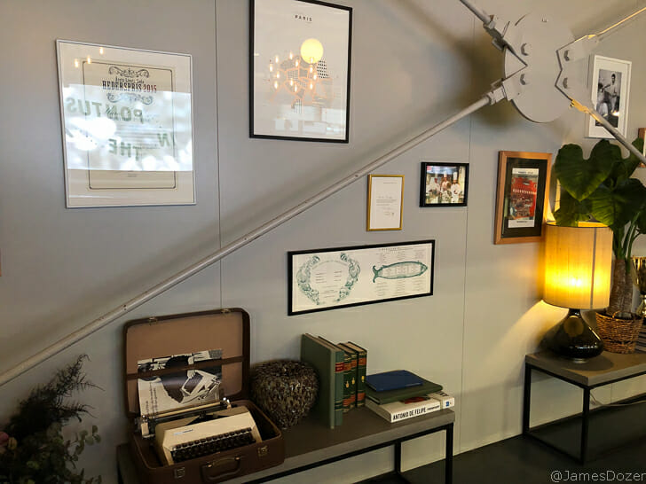 a room with a lamp and a table and books
