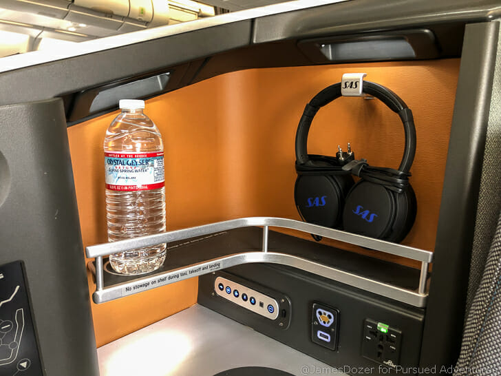 a water bottle and headphones on a shelf