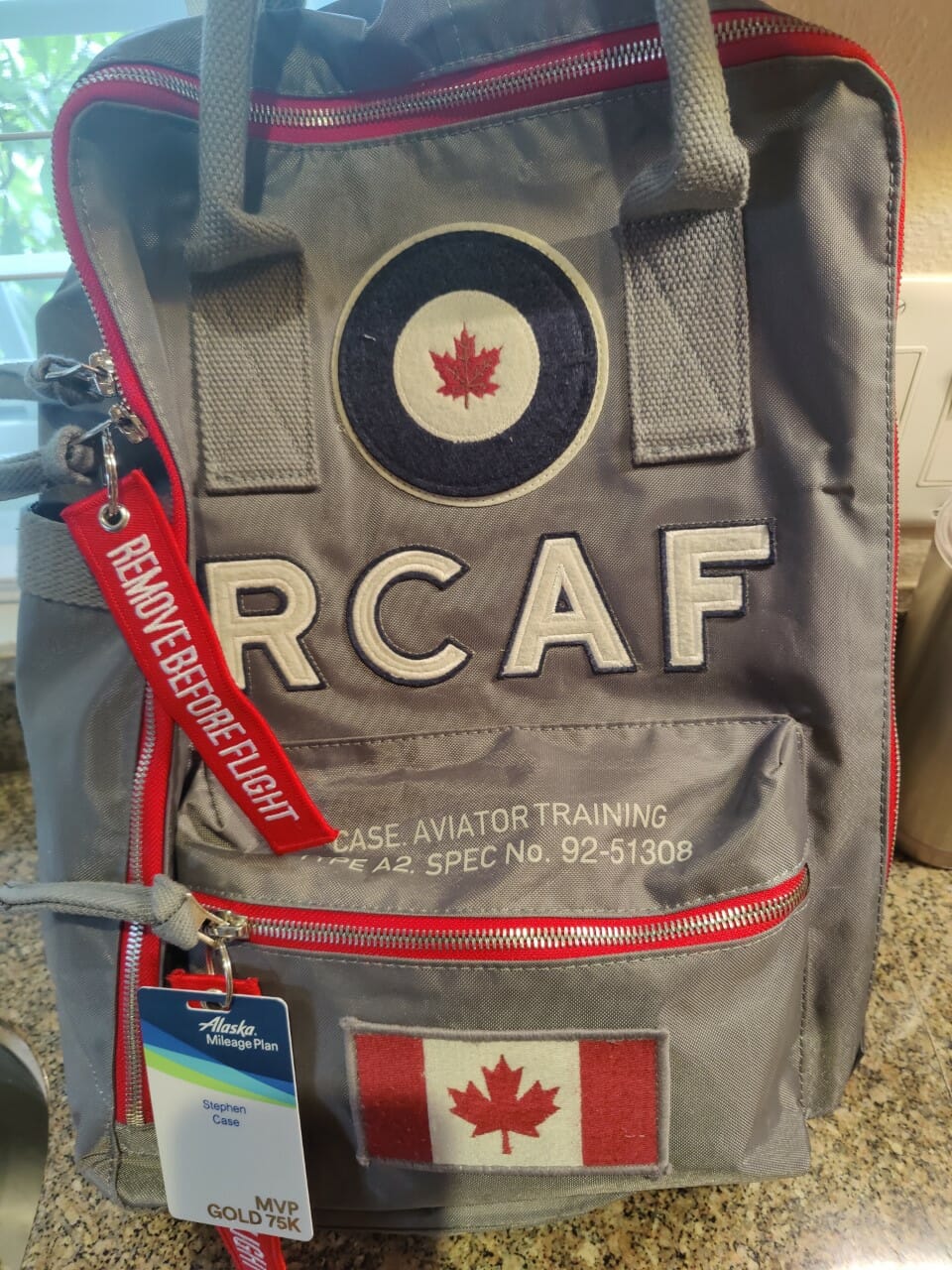 a grey backpack with red and white text