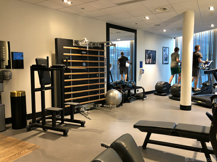 a room with exercise equipment and a couple of people standing in front of it