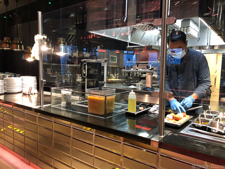 a man wearing a mask and gloves cooking food in a kitchen
