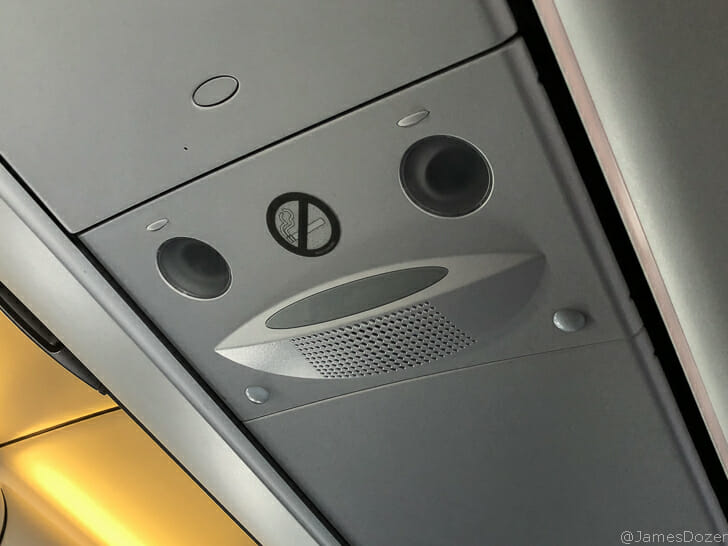 a grey panel with speakers and a sign on it