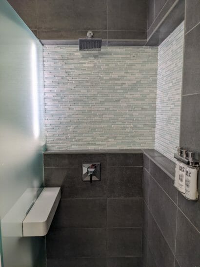 a shower with a tile wall