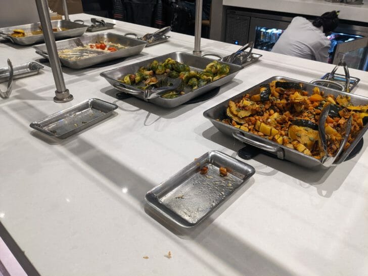 a group of metal trays with food on a table