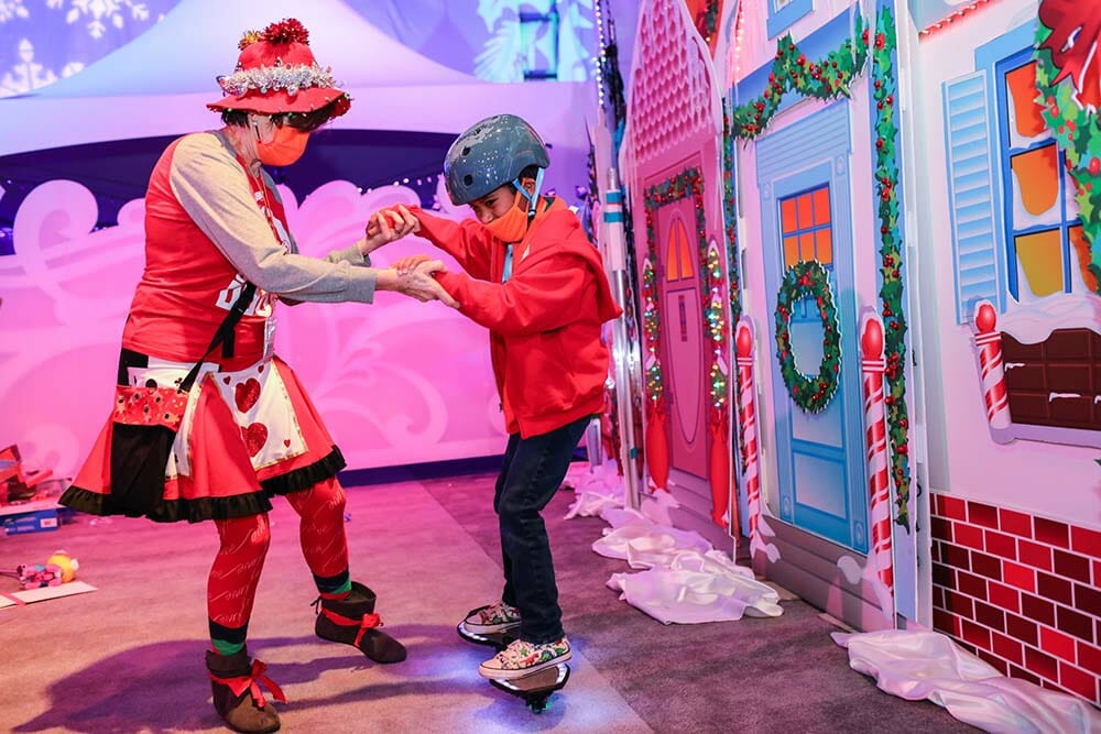 a woman and boy wearing red and green outfits holding hands