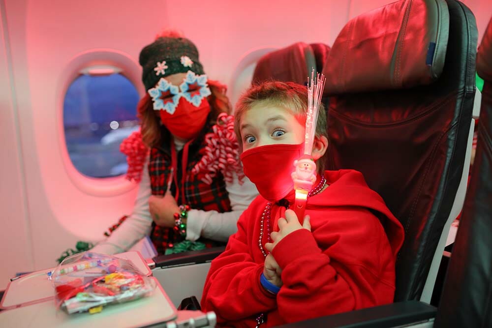 a boy and girl in a red mask and red mask on an airplane