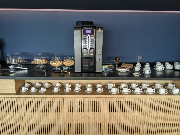 a counter with a variety of coffee cups and cereals