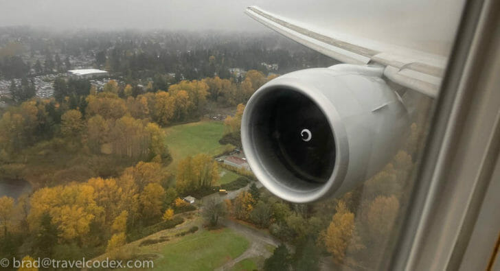 an airplane wing with trees in the background