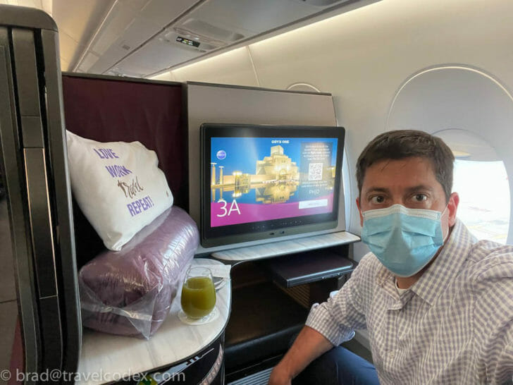 a man wearing a face mask sitting in an airplane