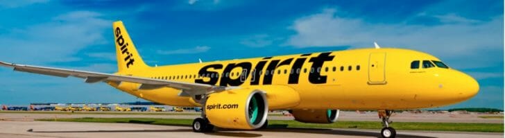 a yellow airplane on a runway with Big Banana in the background