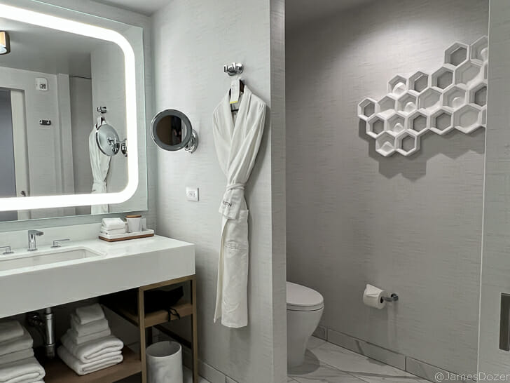a bathroom with a white robe and a mirror