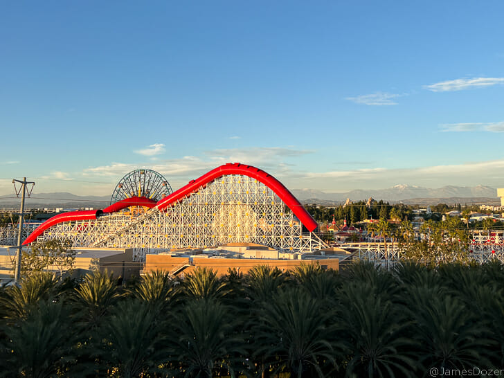 a roller coaster with trees and mountains in the background