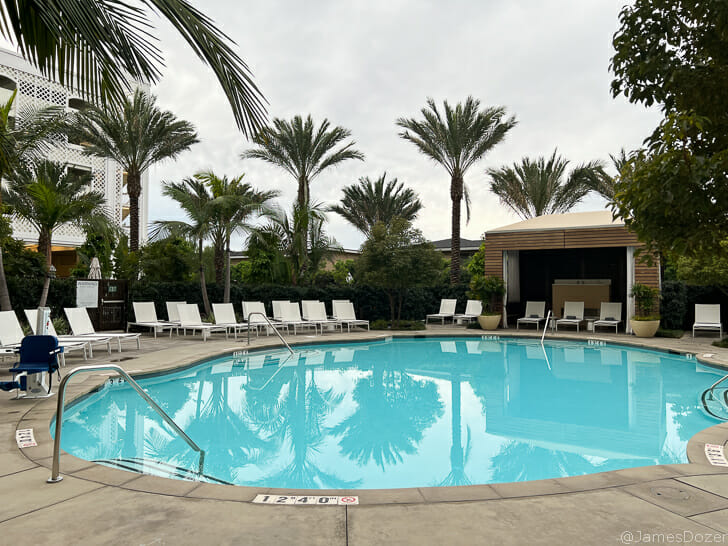 a pool with lounge chairs and trees
