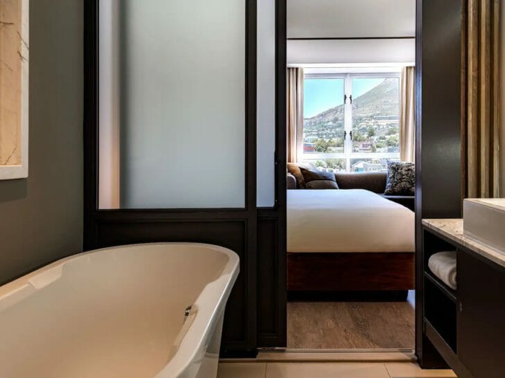 a bathroom with a bathtub and a bed