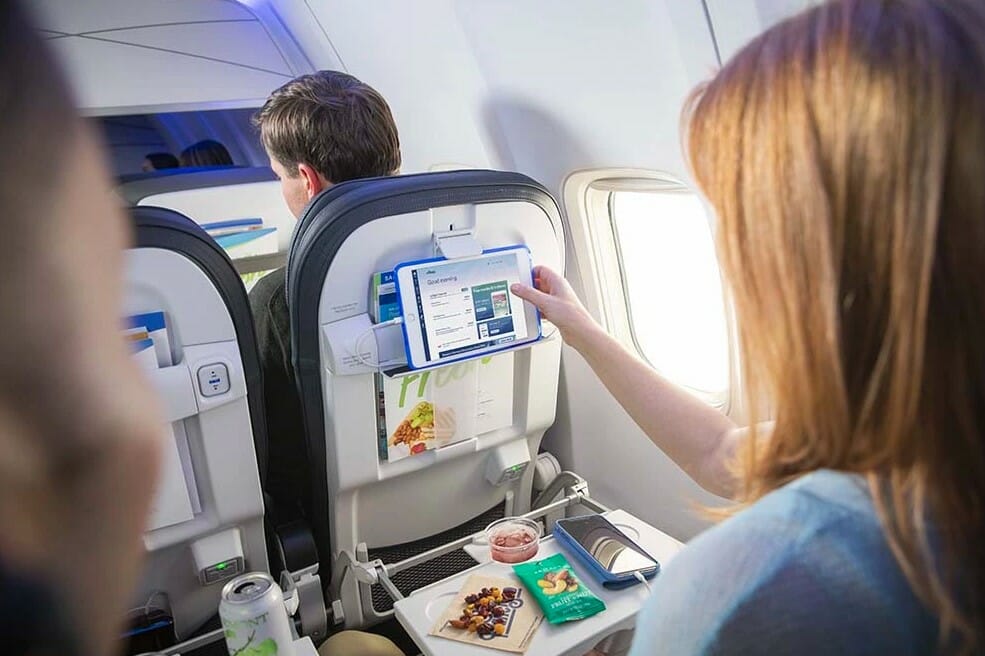 a woman using a tablet on a plane